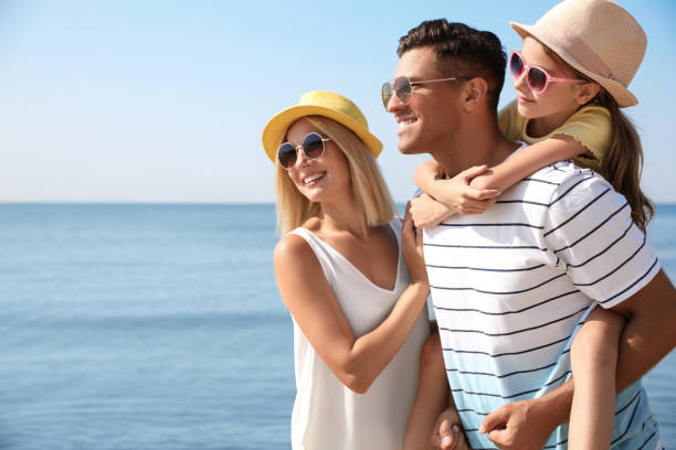 szczęśliwa rodzina na plaży w słoneczny letni dzień - fun mother sunglasses family zdjęcia i obrazy z banku zdjęć