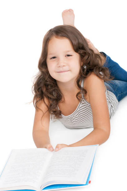 istock Pretty little girl reading a book on a floor 1366084794