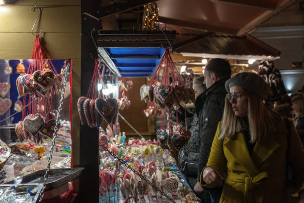 Selective blur on a woman, client, at a stand of Belgrade christmas market selling Candies, candy sticks, sweets and lollilpops, diversified, display in loose. stock photo