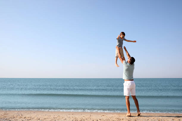 istock Father playing with son at beach. Family vacation 1366085738