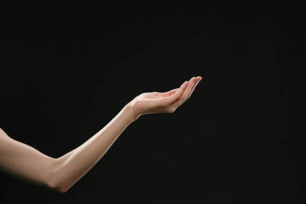 arm and hand of woman on black background