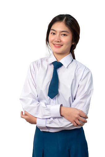 Portrait of Thai student in uniform standing and crossed arm with smile isolated on white background. Confident of beautiful woman looking at camera. Relax and happy concept