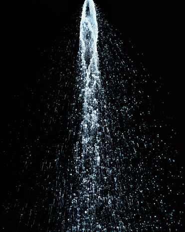 Water jet flowing in motion on black background high resolution