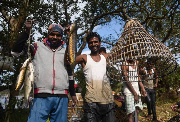 Bhogali Bihu Festival in Assam Kamrup, India. 13 January 2022. Villagers participate in a community fishing event on the occasion of Bhogali Bihu Festival at Goroimari Lake in Panbari village, in Kamrup district of Assam in India on January 13, 2022. Bhogali Bihu or Magh Bihu is celebrated during the month of January which marks the end of the harvest season. guwahati stock pictures, royalty-free photos & images