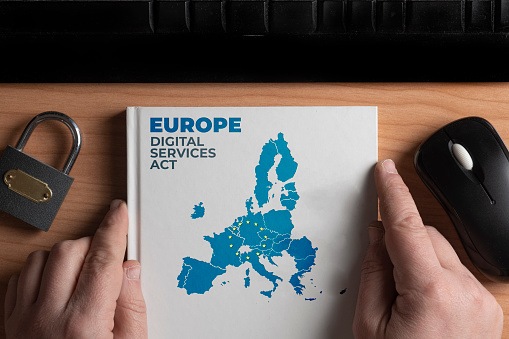 Digital services act concept: man hold a book with european union shape and the text Europe digital services act