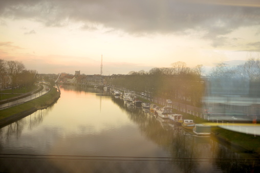 Brugge, West-Flanders, Belgium - January 20, 2022:  Motion blur landscape from Blankenberge towards Bruges on the way view canal waterway with jetties for pleasure yachts
