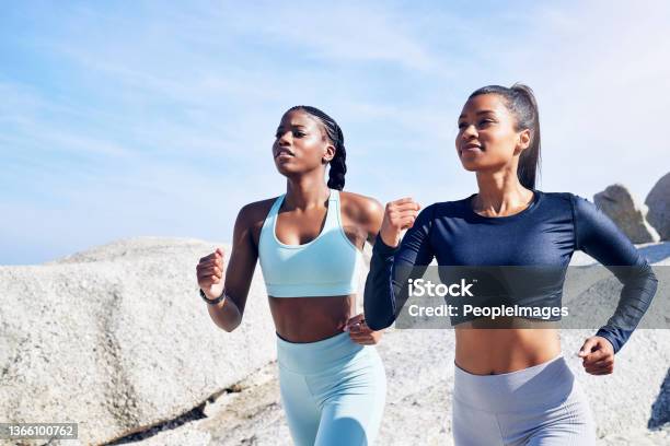 Shot of two fit young women out for a run along the beach