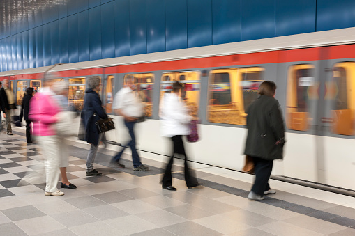 Large group of blurred people getting into subway train in Hamburg, Germany.