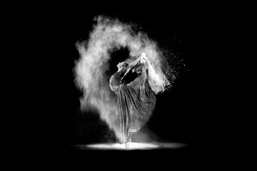 Young dancer dancing with powder on black.