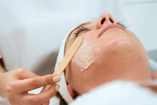 dermatologis mengoleskan krim pengelupasan ke wajah wanita - exfoliating mask potret stok, foto, & gambar bebas royalti