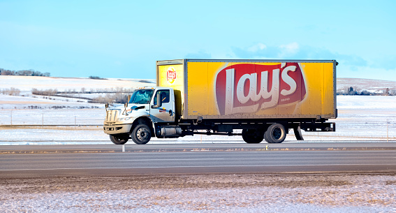 A Lays potato chip truck hauling cargo south on the Queen Elizabeth II Highway near Airdrie, Alberta, Canada. Taken on January 11, 2022