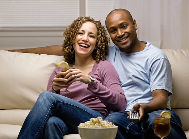 istock Couple with popcorn and remote control, drinking & watching television 136610819
