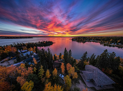 The fall colors at Emma Lake in Northern Saskatchewan, Canada add texture and vibrance to the forest surround the water as the sun sets.