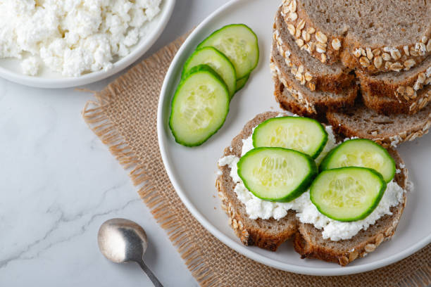 rebanadas de pan de centeno con requesón y pepinos sobre fondo blanco - cottage cheese fotografías e imágenes de stock