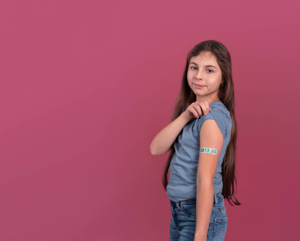 istock Girl showing patch on arm after vaccination in studio 1366115759