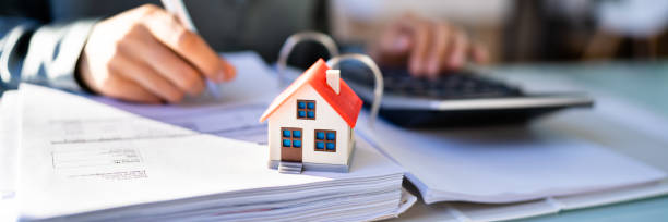istock Person Hand Doing Property Tax Calculation Using Calculator 1366115992