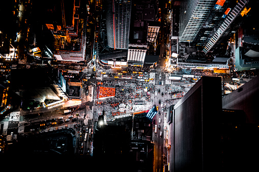Aerial view directly from above on famous Time Square in New York seen during the night with all shining lights and vibrant colours and photographed from a helicopter.