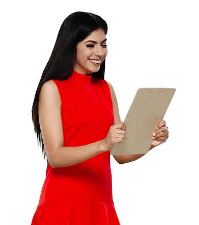 Side view of aged 20-29 years old who is beautiful with long hair latin american and hispanic ethnicity female standing in front of white background wearing dress who is happy and holding document