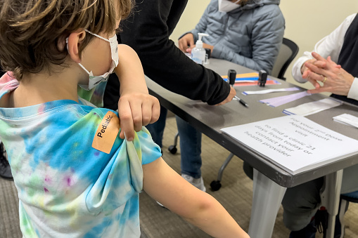 Caucasian Six years old child waiting in line before being vaccinated