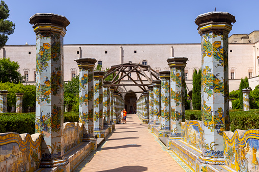 Naples, Italy - June 27, 2021: Cloister Santa Chiara with octagonal columns decorated with majolica tiles in rococo style with floral patterns