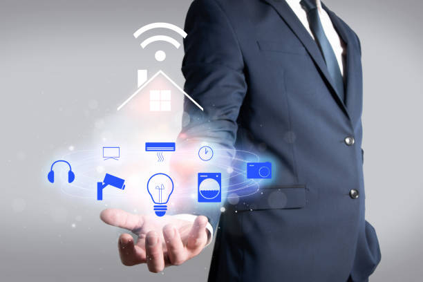 istock Man in jacket holding a house connected by wifi to different electronic devices. Home automation in the home 1366125330