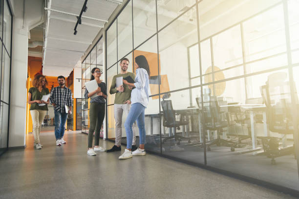 Full-length photo of positive young coworkers in office building stock photo