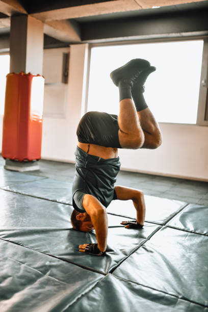 istock Modern Male Gymnast Performing Headstand Exercise In Gym 1366126025