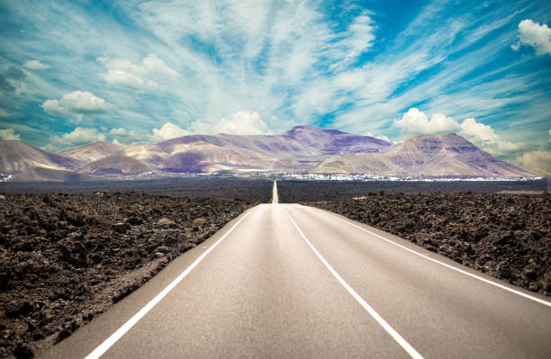 istock Empty highway with mountain and blue sky in the background 1366126522