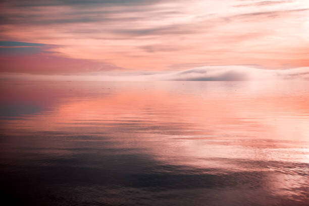 pink sunset over water with fog and clouds - water tranquil scene puget sound cloudscape imagens e fotografias de stock