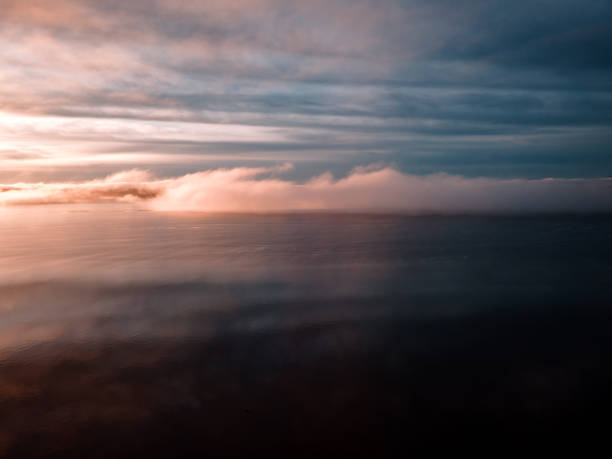 istock Pink Sunset Over Water With Fog and Clouds 1366127767