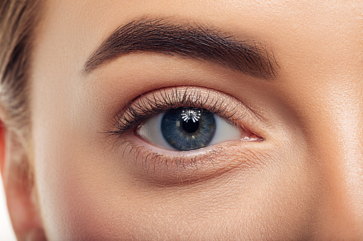 Macro shot of female eye, iris, cropped on black background, usable as creative background