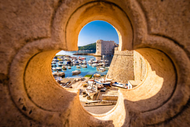 istock Dubrovnik. Historic Dubrovnik harbor view through carved stone wall 1366131875