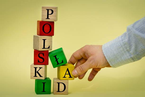 istock A hand pulling a wooden element from a collapsing tower built of blocks with the inscription Polski Åad (Polish language) Concept, introduction of a bug-free economic program in Poland, State finance reform 1366137709