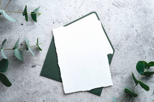 istock Wedding stationery set. Wedding invitation card mockuyp, green envelope, eucalyptus branches on concrete background. Flat lay, top view, copy space. 1366137748
