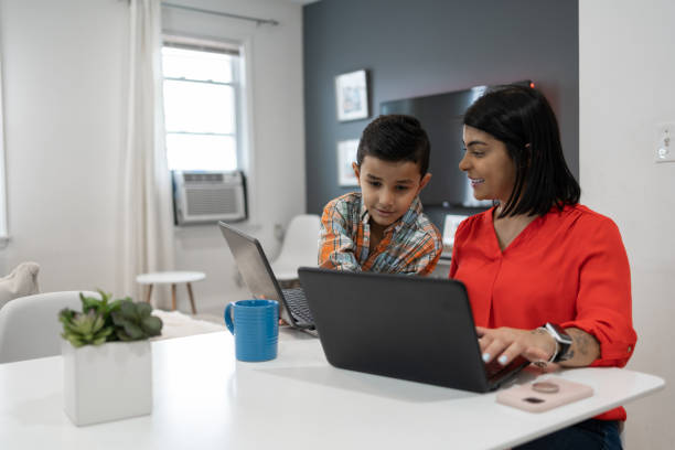 istock Latin mother and son using multiple devices at home 1366137858
