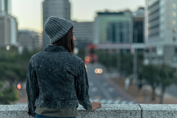 Rearview shot of an unrecognizable young woman looking at the view from the top of a building outside I forgot about all the beautiful things looking around stock pictures, royalty-free photos & images