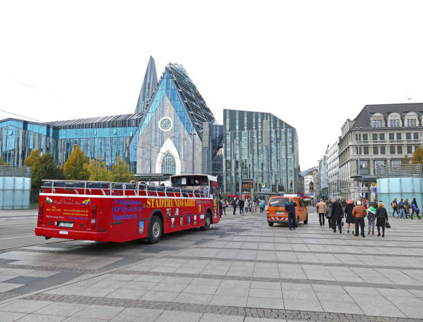 Group of tourists enjoying open top bus tour in the city Leipzig.
