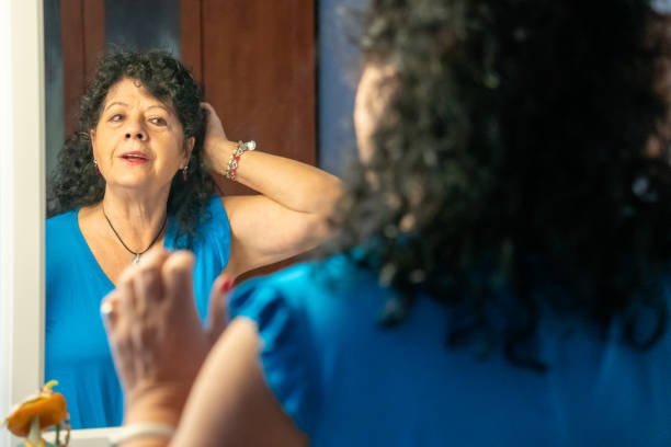 istock Senior woman looking in the mirror while getting tidy up 1366141992