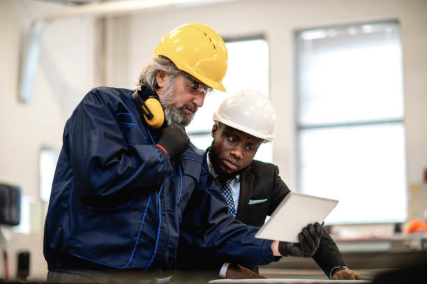 Supervisor and worker discussing in factory stock photo