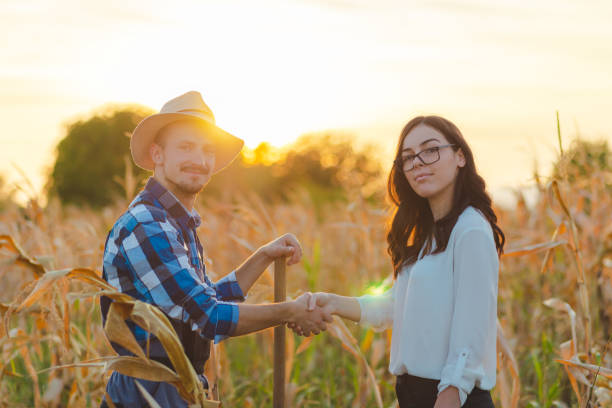 retrato de cintura para arriba de un joven agricultor vestido con una camisa azul estrechando la mano de una inspectora agrícola - waistup fotografías e imágenes de stock