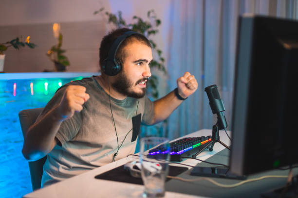 istock Young male gamer celebrating a win on a video game while live streaming from home 1366149418