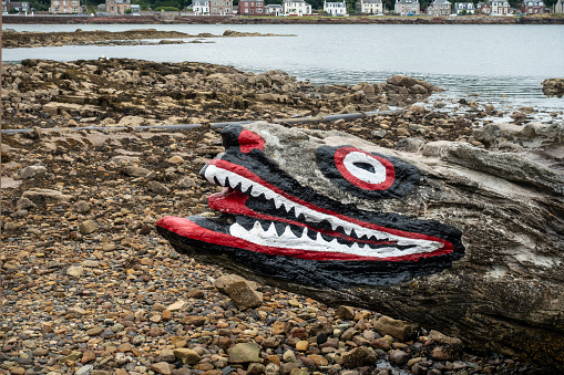 Millport, Scotland, UK - 15th August 2021: Crocodile Rock on the shingle beach on Millport, a seaside holiday town on the Isle of Cumbrae, an island in the Firth of Clyde. It was first painted by a Mr Brown in the early 20th century and has been repainted regularly as a famous local landmark ever since.