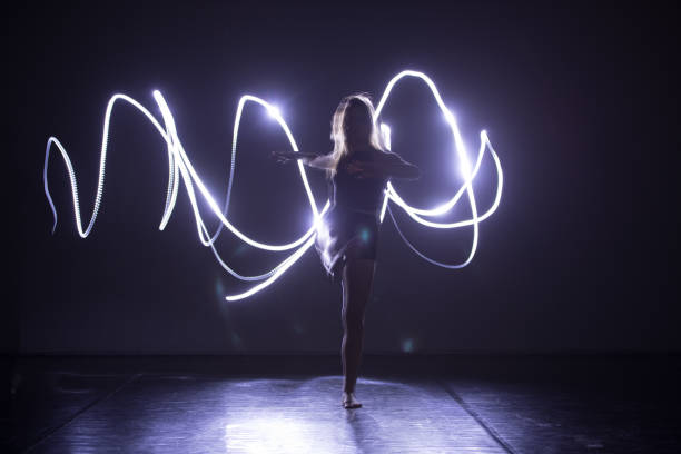 istock Modern Dance performer dancing with a neon blue light while making gracious moves and spectacular body art expressions. 1366153297