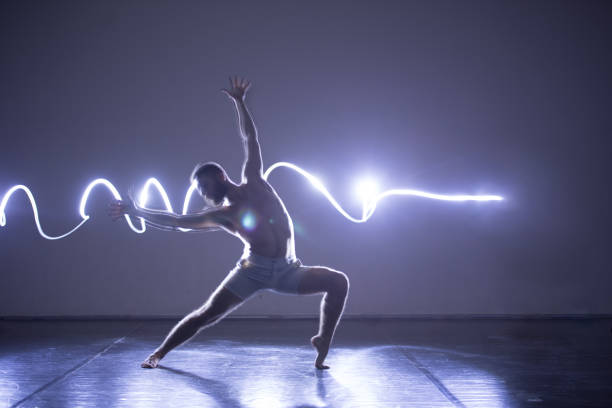 istock Modern Dance performer dancing with a neon blue light while making gracious moves and spectacular body art expressions. 1366153302