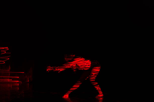 istock Beautiful dancer moving her body in front of and red light while performing a perfect dance composition of moves. The dance scene is showing off the inferno in a spectacular way. 1366153313