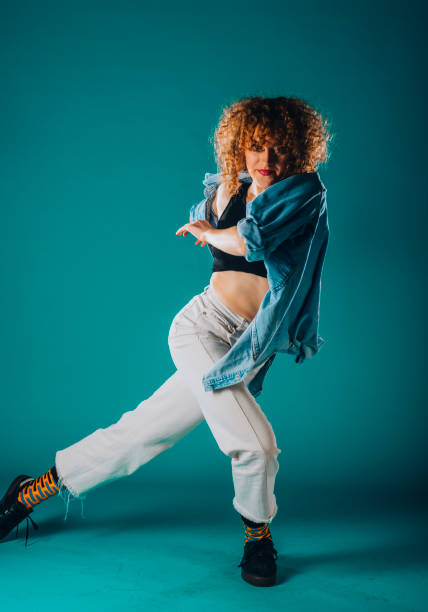 istock Young dance artist perform acrobat moves isolated on cyan background 1366153719