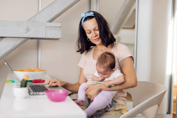 istock Mom works at home with a newborn 1366153868