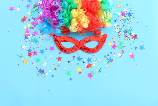 carnival, party and Purim celebration concept (jewish carnival holiday) over blue background
