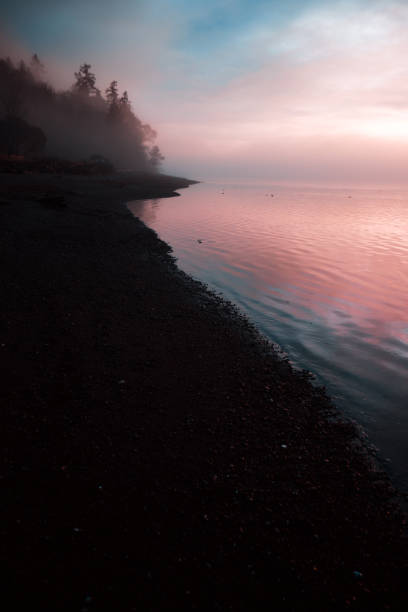 霧と雲の水の上にピンクの夕日 - water tranquil scene puget sound cloudscape ストックフォトと画像