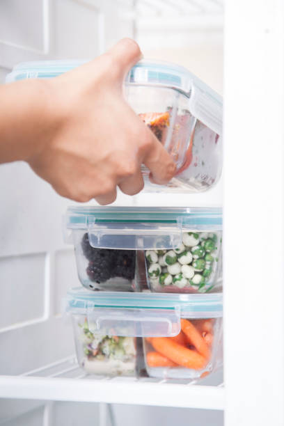 Putting glass food storage containers in refrigerator stock photo
